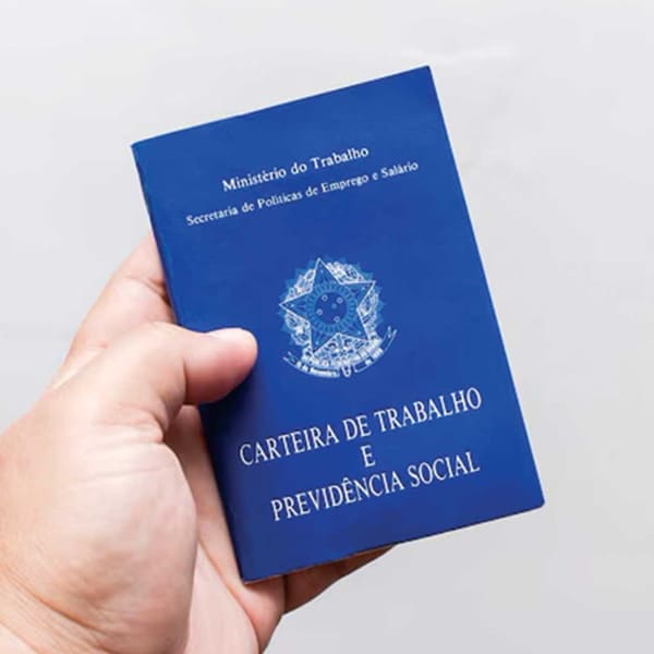Mão segurando uma carteira de trabalho